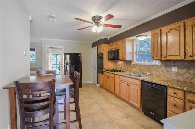 kitchen featuring tasteful backsplash, ornamental molding, a textured ceiling, black appliances, and a sink