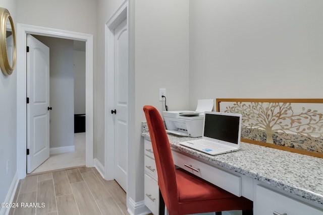 office space featuring built in desk and light wood-type flooring