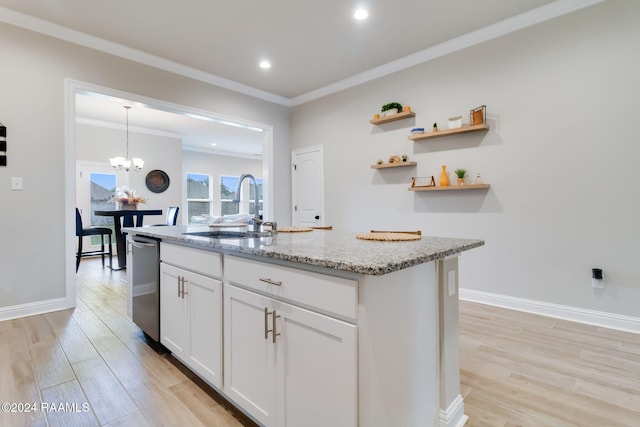 kitchen featuring white cabinetry, a center island with sink, sink, light stone counters, and light wood-type flooring