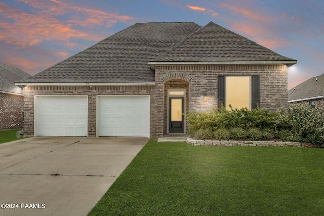 view of front of home featuring a lawn and a garage