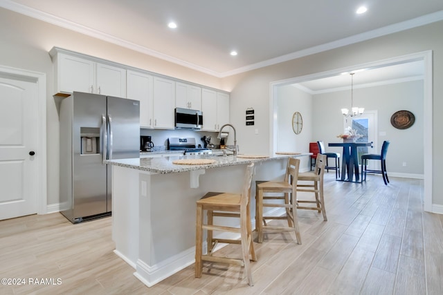 kitchen featuring white cabinets, an island with sink, light hardwood / wood-style floors, and stainless steel appliances