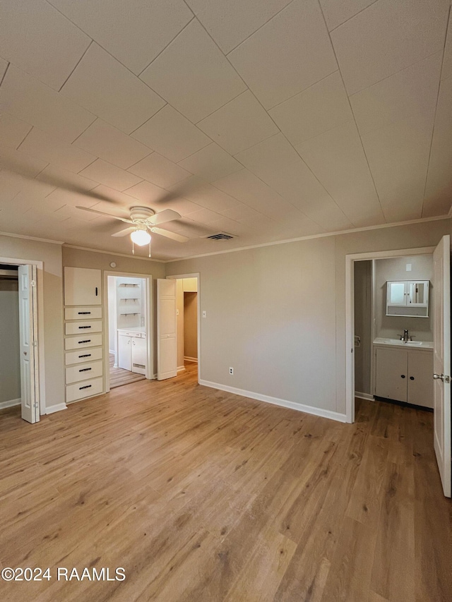 404 W Hickory St, Ville Platte, LA 70586 - unfurnished bedroom featuring light wood-style floors, baseboards, a sink, and a ceiling fan