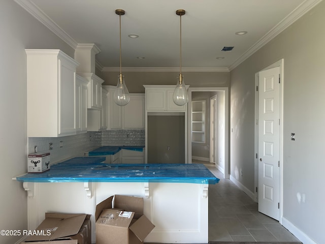 kitchen with decorative light fixtures, white cabinetry, a breakfast bar area, backsplash, and ornamental molding