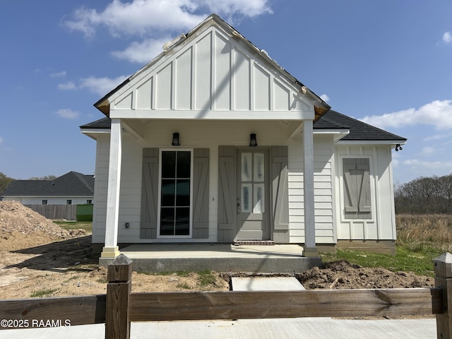 view of front of property featuring covered porch, board and batten siding, and a shingled roof