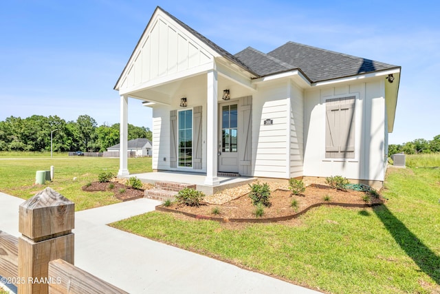 366 W Broussard Rd, Lafayette, LA 70506 - view of front of house featuring covered porch, a front lawn, a shingled roof, board and batten siding, and central air condition unit