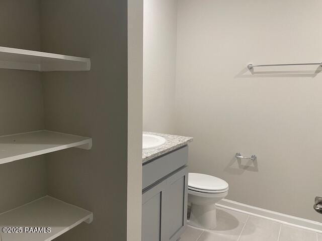 bathroom with toilet, tile patterned floors, and vanity