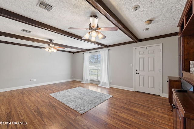 entryway with beamed ceiling, a textured ceiling, dark hardwood / wood-style floors, and ceiling fan