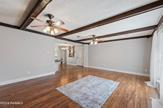 unfurnished living room featuring beamed ceiling, a textured ceiling, ceiling fan with notable chandelier, and hardwood / wood-style flooring