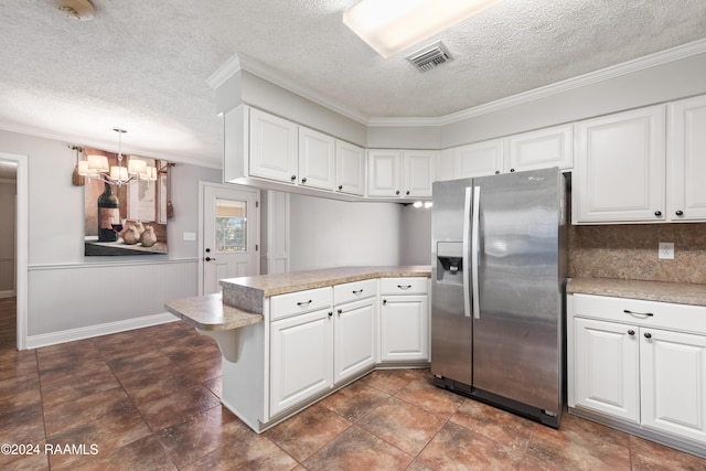 kitchen featuring crown molding, stainless steel fridge, white cabinets, and decorative light fixtures