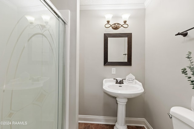 bathroom with crown molding, a shower with shower door, and toilet