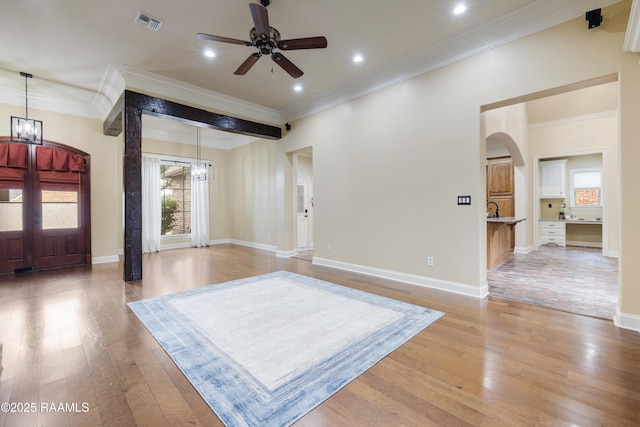 entryway featuring crown molding, ceiling fan with notable chandelier, and light hardwood / wood-style flooring