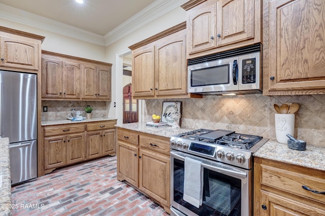 kitchen featuring light stone countertops, ornamental molding, appliances with stainless steel finishes, and backsplash