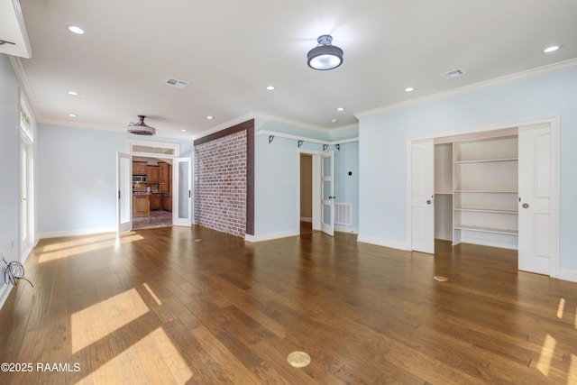 unfurnished living room with ornamental molding, a barn door, and dark hardwood / wood-style flooring