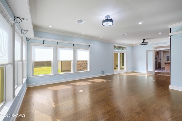 empty room featuring hardwood / wood-style flooring, ornamental molding, and french doors