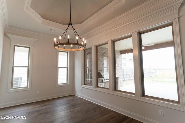 unfurnished dining area with ceiling fan with notable chandelier, dark hardwood / wood-style flooring, a raised ceiling, and crown molding