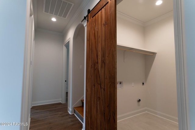 laundry room with electric dryer hookup, crown molding, hookup for a washing machine, a barn door, and wood-type flooring