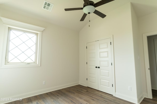 unfurnished bedroom with dark hardwood / wood-style flooring, a closet, vaulted ceiling, and ceiling fan