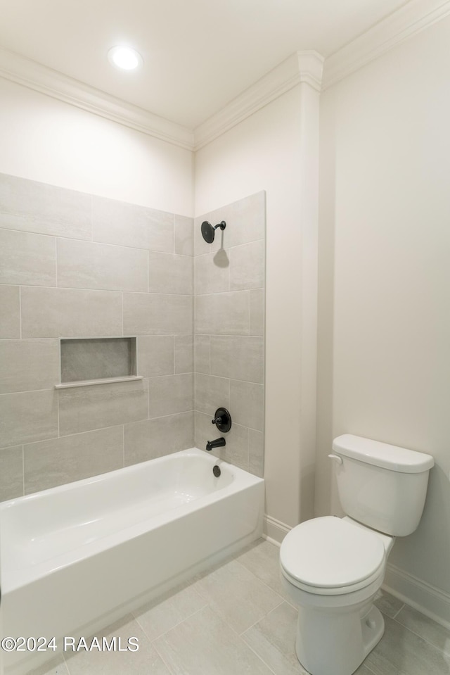 bathroom featuring tile patterned floors, tiled shower / bath combo, toilet, and ornamental molding