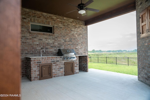 view of patio with ceiling fan, sink, exterior kitchen, a rural view, and grilling area