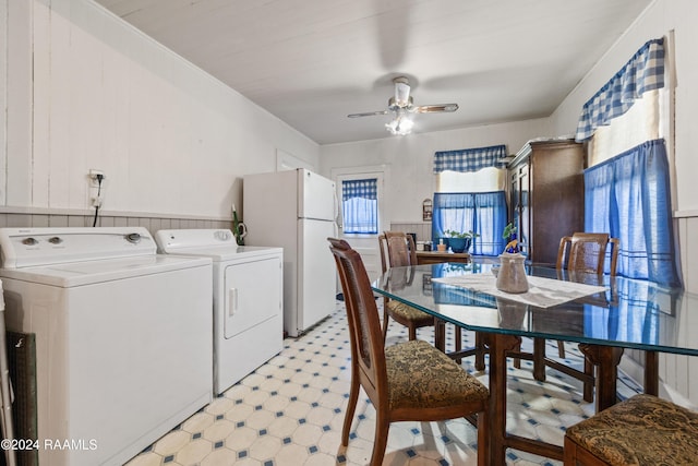 laundry area featuring ceiling fan, wooden walls, and independent washer and dryer