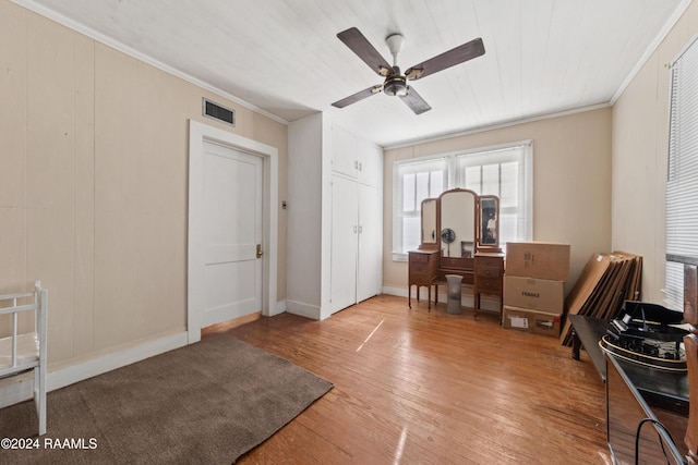 interior space with crown molding, ceiling fan, and wood-type flooring