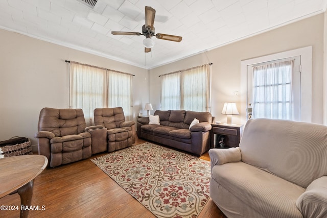 living room with hardwood / wood-style floors, crown molding, and a healthy amount of sunlight