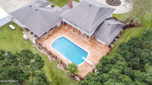 view of pool with a lawn and a patio