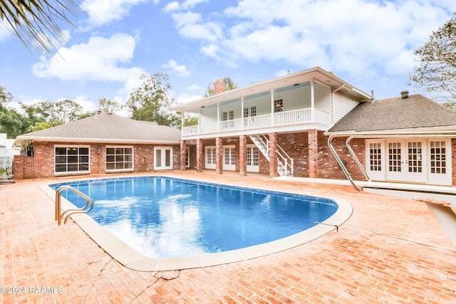 view of swimming pool with french doors and a patio
