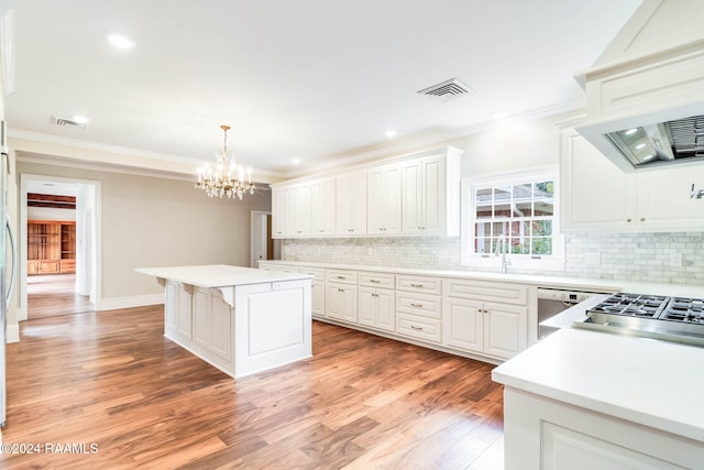 kitchen featuring white cabinetry, light wood-type flooring, decorative light fixtures, and a center island