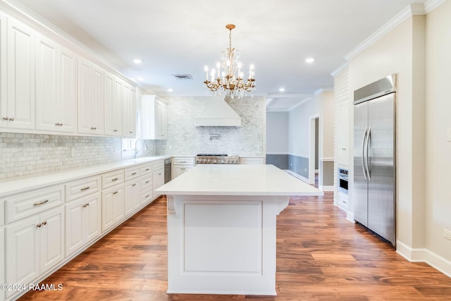 kitchen featuring white cabinetry, hardwood / wood-style floors, appliances with stainless steel finishes, and a kitchen island