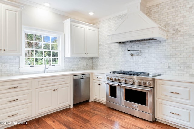 kitchen with hardwood / wood-style floors, appliances with stainless steel finishes, and crown molding