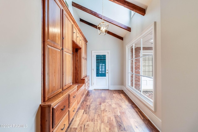 mudroom with lofted ceiling with beams and light hardwood / wood-style flooring
