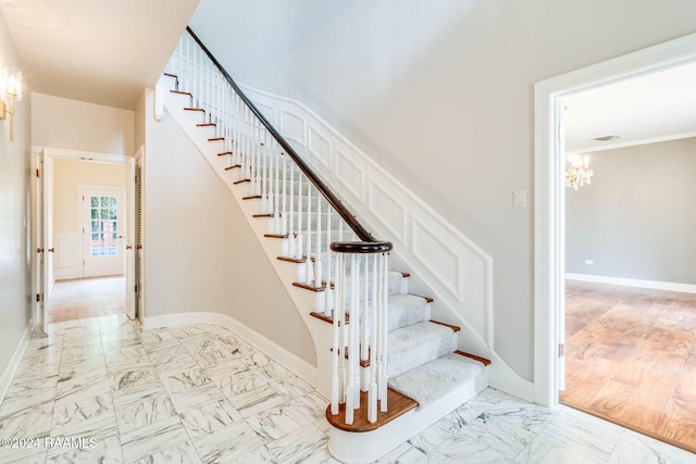 stairway featuring an inviting chandelier and hardwood / wood-style flooring