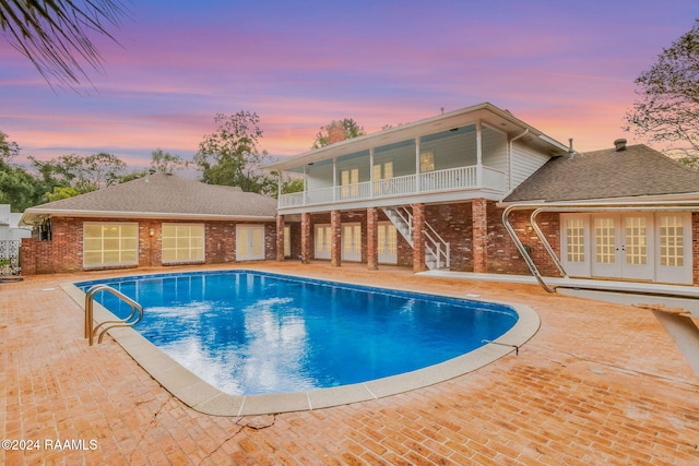pool at dusk featuring a patio area