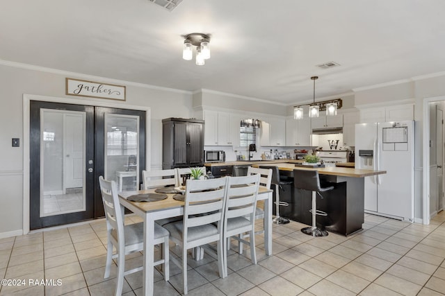 tiled dining room featuring crown molding, french doors, a chandelier, and sink