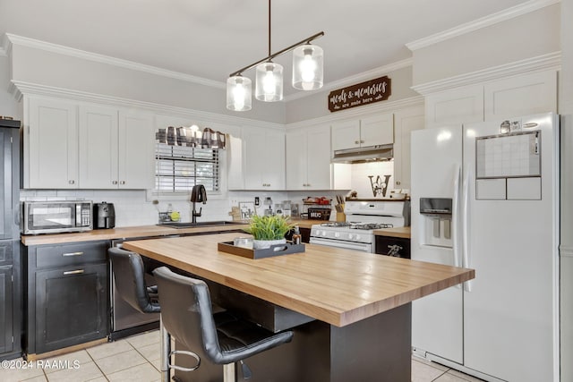 kitchen featuring wooden counters, stainless steel appliances, white cabinets, and sink