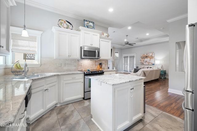 kitchen with pendant lighting, ceiling fan, light hardwood / wood-style floors, white cabinetry, and stainless steel appliances