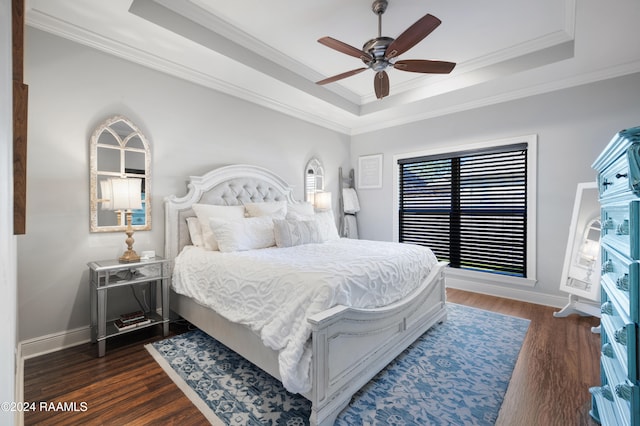 bedroom featuring dark hardwood / wood-style flooring, a tray ceiling, ceiling fan, crown molding, and multiple windows