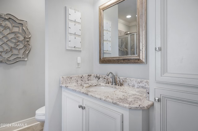 bathroom with walk in shower, crown molding, vanity, and toilet