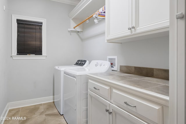 washroom with washer and clothes dryer, light tile patterned flooring, and cabinets