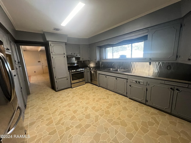 kitchen featuring sink, appliances with stainless steel finishes, gray cabinetry, and tasteful backsplash