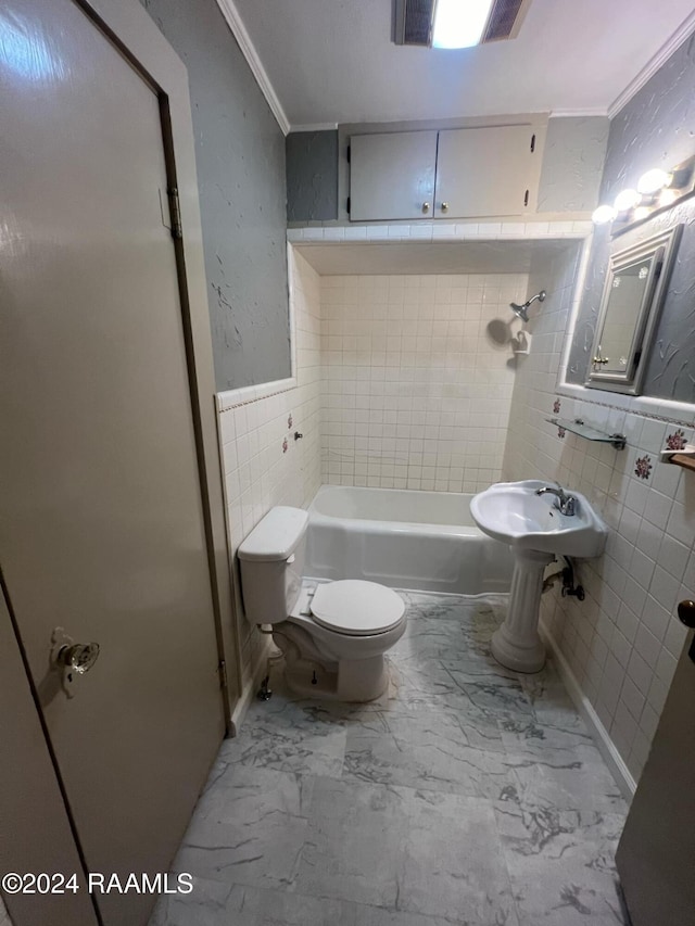 bathroom with tile walls, ornamental molding, tiled shower / bath, and toilet