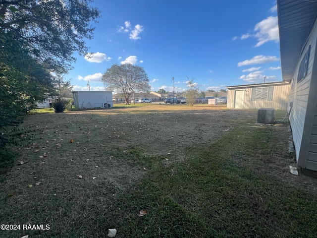 view of yard with a shed and central AC unit