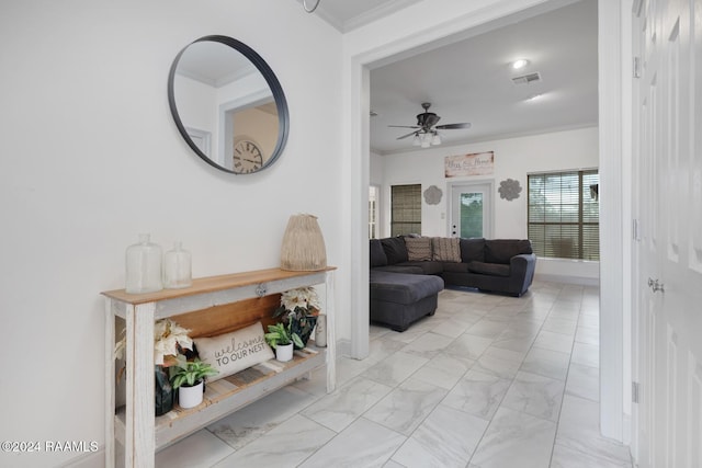 living room featuring ceiling fan and crown molding