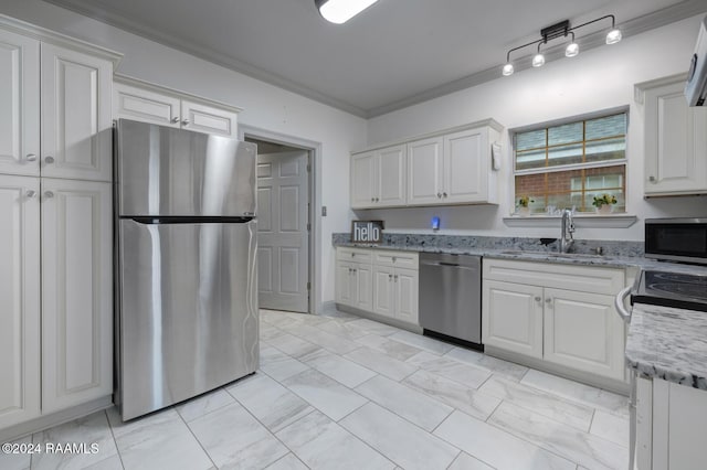 kitchen with light stone counters, ornamental molding, white cabinetry, appliances with stainless steel finishes, and sink