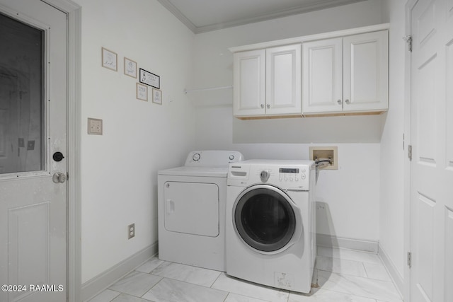 laundry area featuring cabinets, washing machine and dryer, and ornamental molding