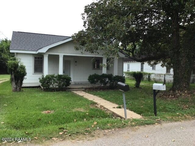 view of front facade featuring covered porch and a front yard