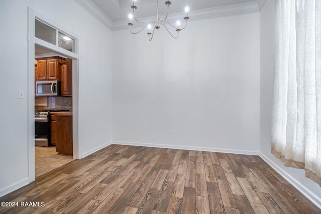 unfurnished dining area with a notable chandelier, ornamental molding, and wood-type flooring