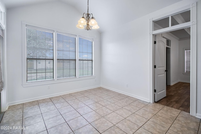 unfurnished room featuring light hardwood / wood-style flooring, lofted ceiling, and a chandelier