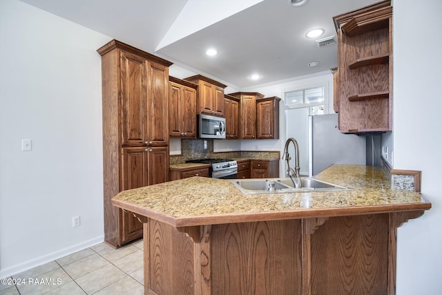 kitchen featuring appliances with stainless steel finishes, kitchen peninsula, sink, and a breakfast bar area